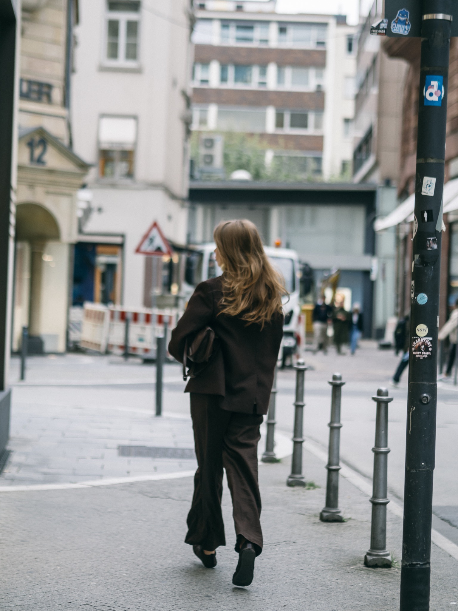 Street-style fashion photograph of a woman walking through the city
