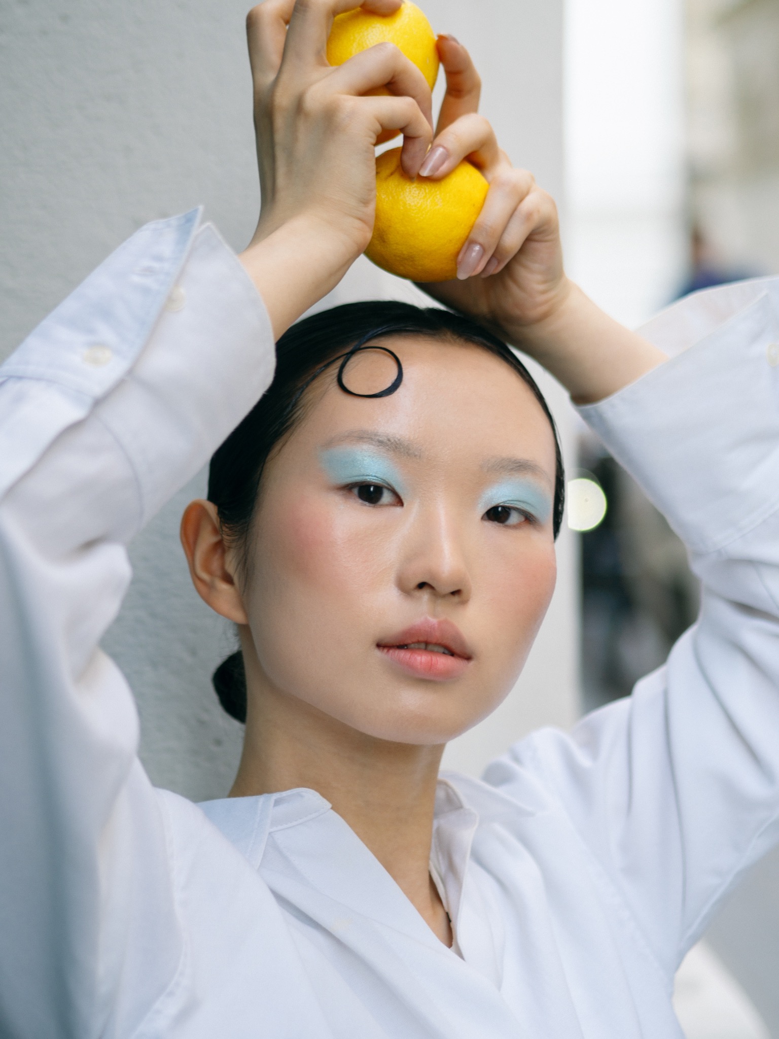Creative portrait with lemons and blue eye makeup
